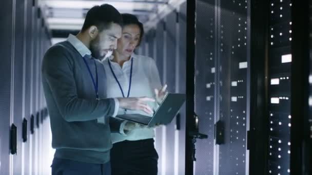 Férfi és női mérnökök működését a szerver egy laptop-ban adat központ. Kinyitja a Rack szerver szekrény. — Stock videók