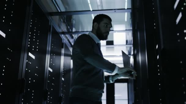 Homme Ingénieur informatique Ouvre armoire de serveur tout en tenant ordinateur portable. Il travaille dans le Big Data Center — Video