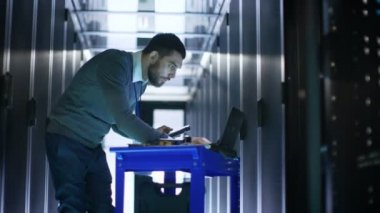 Bu mühendis inşaat üstünde bir Laptop ve inceden inceye gözden geçirmek sabit sürücüler o Lying Crash Cart üzerinde vardır. Veri merkezinde çalışıyor.