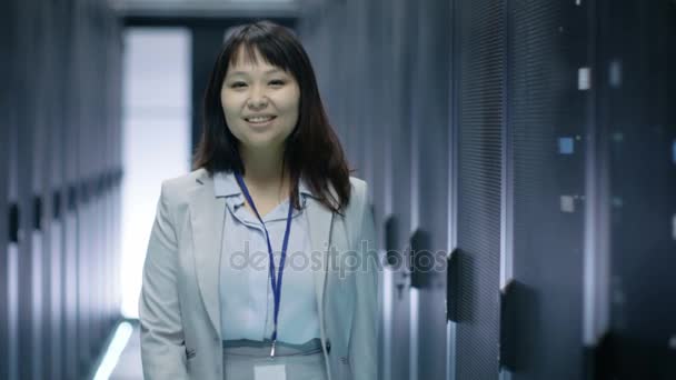 Veri merkezinde raf tipi sunucular tam ayakta iken close-up kadın Asya bu mühendis gülümseyen. — Stok video