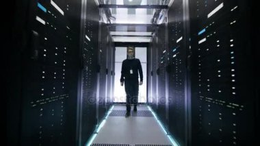 Veri Merkezi koridor raf tipi sunucular, satırlarla yürürken aşağıdaki kadeh mühendisi.