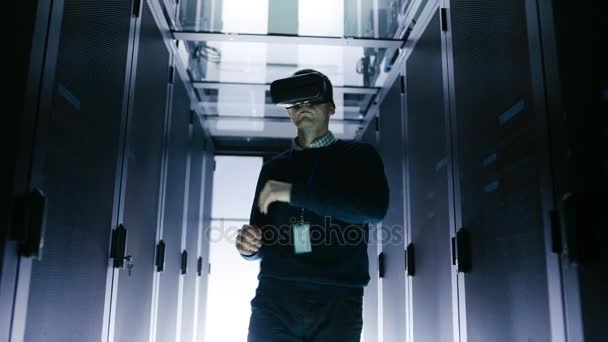 Het ingenieur dragen van Virtual Reality Headset werkt met Augmented Reality Software in datacenter. Hij communiceert draadloos met rackservers. — Stockvideo