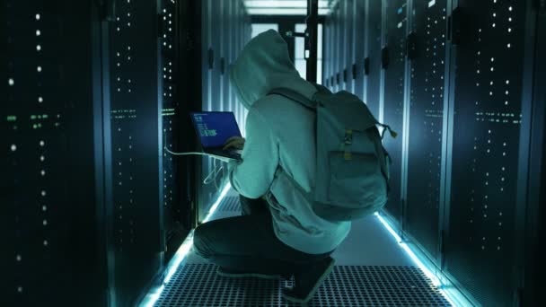Hacker met Laptop verbindt met rackserver en steelt informatie uit Corporate Data Center. — Stockvideo