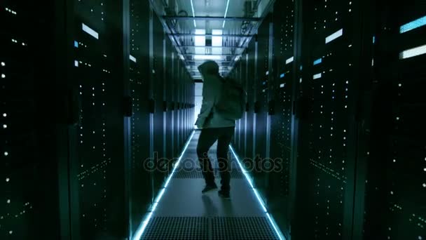 Follow Shot of a Masked Hacker in a Hoodie Running Away with Laptop in a Corporate Data Center. — Stock Video