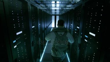 Veri Merkezi koridordan yürürken Hoodie koyarak bir Hacker görüntüsünü izleyin.