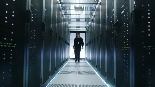 Frontal View of IT Engineer Walking Through Data Center with Working Rack Servers. — Stock Video