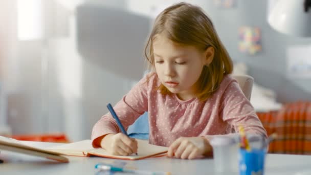 Söt ung flicka gör läxor i sitt sovrum. — Stockvideo