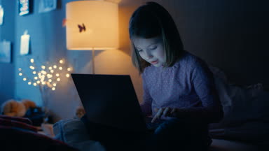 Zeki genç kız yatak odasında gece geç saatlerde dizüstü bilgisayar ile onun yatağında oturur ve ilginç bir şey türleri. Onun gece lambası yanıyor.