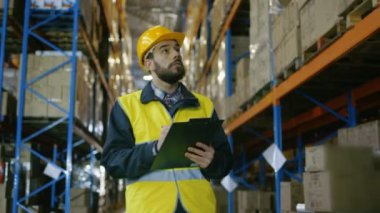 Kask tutar Tablet bilgisayar giyen surveyor mal ambarındaki sayar. O mal ile depolama rafları satırlarının size yürür.