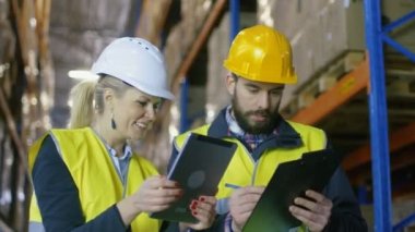 Tablet bilgisayar ve pano var ambar ile tartışma büyük palet rafları ile erkek Surveyor kadın yönetici.