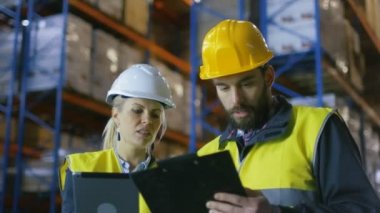 Tablet bilgisayar ve pano var ambar ile tartışma büyük palet rafları ile erkek Surveyor kadın yönetici.