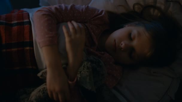 Tatlı küçük kız uyuyor onu yatakta iken sarılma onu peluş oyuncaklar. — Stok video