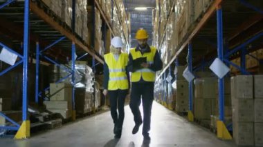 Kadın yönetici ve erkek Audidor büyük perakende depo ile yürüyüş.