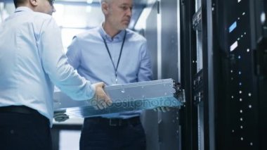 İki sunucu teknisyen Server rafa donanımı yükleyin. Onlar büyük Modern veri merkezinde iş.