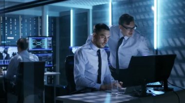 İki işlem mühendis sisteminde sorunları çözme üzerinde çalışıyor kontrol odası. Arka plan kendi meslektaşı, görüntüler ve sunucu rafları.