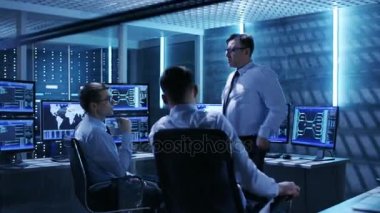 Teknik moderatörlerin ekip tartışma var oda izleme. Sistem kontrol odası çalışma görüntüler ve sahip sunucular raflar dolu.