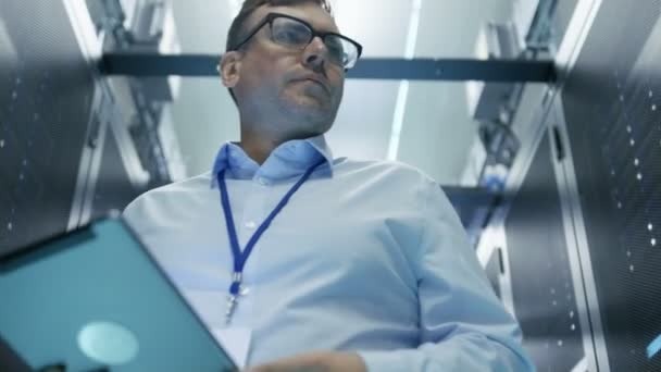 Server-technicus werkt in datacenter. Ze lopen door het samenwerken van rijen van Server Racks. — Stockvideo