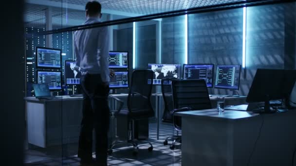 Dos ingenieros técnicos toman sus lugares en la sala de control de la misión. La sala de monitoreo tiene múltiples computadoras y su propio centro de datos . — Vídeo de stock