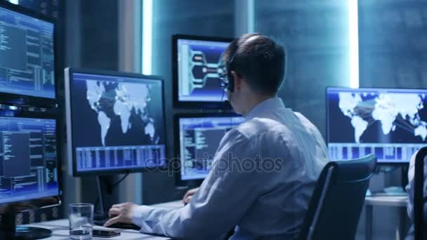 Vista panorámica de los profesionales que trabajan en el centro de control del sistema lleno de pantallas con varios datos y con sus propios bastidores de servidor . — Vídeos de Stock