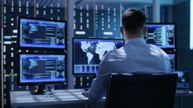 Arkadan görünüşü teknik denetleyicisi / operatör çalışma onun iş istasyonunda birden çok ekran ile. Olası santral / Havaalanı dağıtıcı / baraj işçi / hükümet gözetim / uzay programı