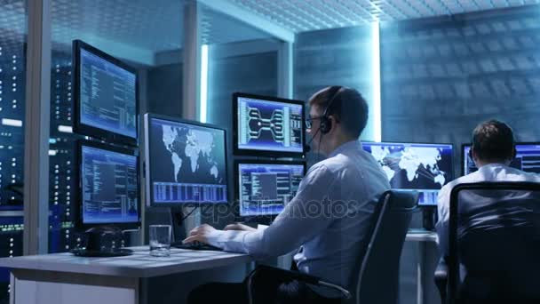 Panoramatickém záběru systém řídící místnosti se třemi technické řadiči pracovat na jejich pracovních stanicích s více monitorů. — Stock video