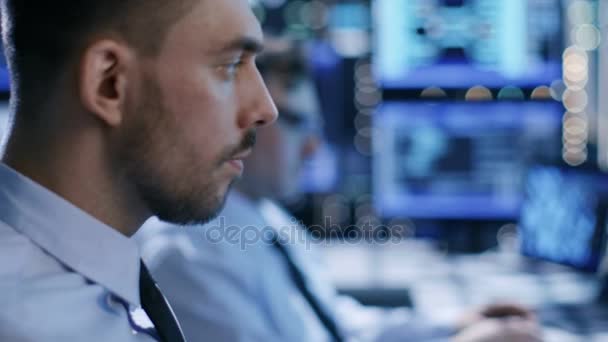 In het System Control Center-Team van technici de stabiliteit van het systeem van de Monitor. Close-up gezichten beeldmateriaal. Mogelijke luchtverkeer / elektriciteitscentrale / veiligheid thema kamer. — Stockvideo