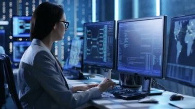 Kadın sistem mühendisi operasyonel işlemleri denetler. Arka plan kişilerde çalışma ve monitörler çeşitli bilgileri göster. 