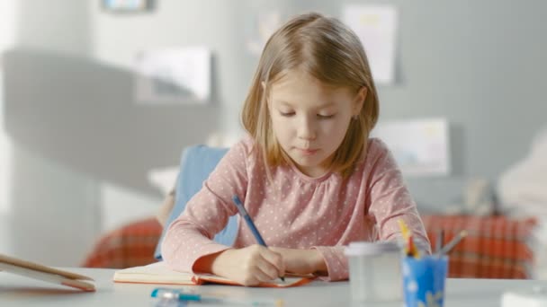 Intelligentes kleines Mädchen schreibt in ihr Tagebuch, während sie in ihrem Zimmer sitzt. — Stockvideo