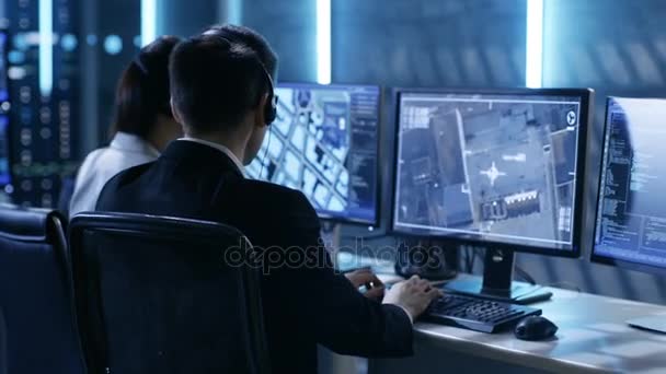 I regeringens Agentur System Surveillance Center Medarbejdere Trace Criminal med hjælp af GPS. Deres værelse er fuld af skærme med forskellige data på dem . – Stock-video