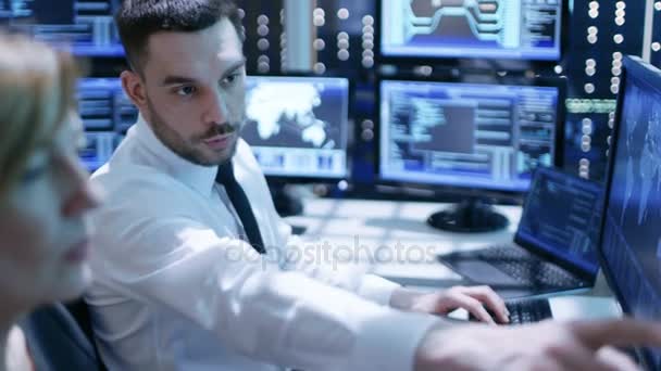 Dolly Shot of Engineers Trabalhando em seus computadores na sala de monitoramento. Muitas telas com vários dados e informações estão na sala . — Vídeo de Stock