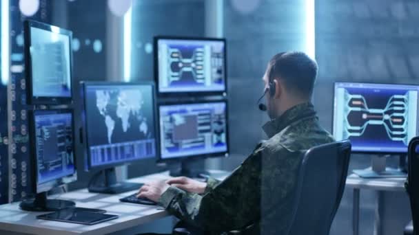 女性と男性の軍事テクニカル サポートの担当者は、ヘッドセットに指示を与えます。彼らは多くのシステム制御室の作業画面. — ストック動画