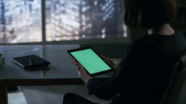 Over the Shoulder View of Businesswoman Sitting at Her Desk and Using Tablet Computer with Green Screen. Big City is Seen out of the Window. — Stock Video