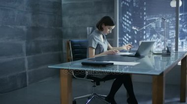 Başarılı genç kadın onun Resepsiyon ve bir dizüstü bilgisayar, işaretler önemli belgeler üzerinde çalışır özel ofisinde oturuyor. Onun ofisi Minimalist tarzda yapılır, oldukça karanlık ve pencere vardır büyük şehir manzaralı.