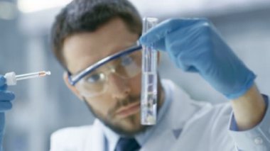 Bir Modern laboratuvar gıda bilim adamı yürüten deneylerde kullanımı Damlalık ve tüp bebek fabrikasında sentezleme bileşikler tarafından.