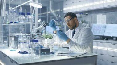 Bir Modern laboratuvar araştırma bilim adamı yürüten deneylerde kullanımı Damlalık ve tüp bebek fabrikasında sentezleme bileşikler tarafından.