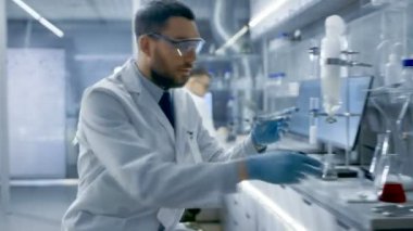 Biyolojik malzeme, Uses mikroskop ile Modern laboratuvar araştırma bilim adamı deneylerde ve sonuçları yazıyor.