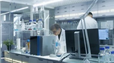 Kamera çekim, yüksek teknoloji Ultra Modern laboratuvar bilim adamları iletken ile deneyler taşıyarak, bilgisayarlar ve karıştırma kimyasallar üzerinde çalışma.