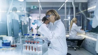 High Tech Ultra Modern laboratuvar deneyleri, bilim adamları iletken ile çalışan bilgisayarlarda, mikroskobu ve kimyasal karıştırma altında madde bakarak.