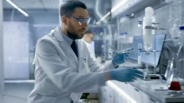 Em um laboratório moderno, o cientista de pesquisa experimenta com materiais biológicos, usa microscópio e escreve os resultados . — Vídeo de Stock
