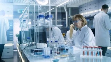 Bilim adamları iletken deneyler ile yükseltilmiş görüntüleri, High Tech Ultra Modern laboratuvar mikroskop ve kimyasal karıştırma altında madde bakarak bilgisayarlarda çalışma.