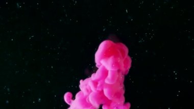 Pembe ve sarı mürekkep siyah su tankı içine ateş eder.