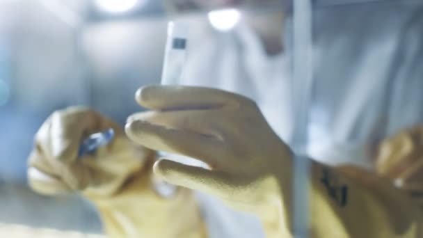 Senior Female Scientist Works with Samples in Isolation Glove Box. Elle est dans un laboratoire moderne équipé d'une technologie de pointe . — Video