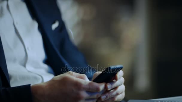 Empresario utiliza Smartphone mientras está sentado en su oficina privada con vista a la ventana de la gran ciudad . — Vídeos de Stock
