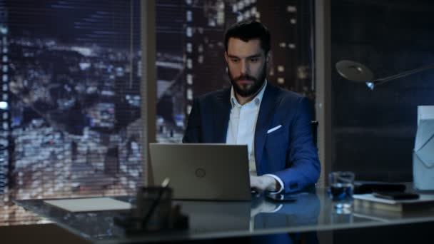 商人在笔记本电脑上工作在他的私人办公室，与大城市窗口视图. — 图库视频影像