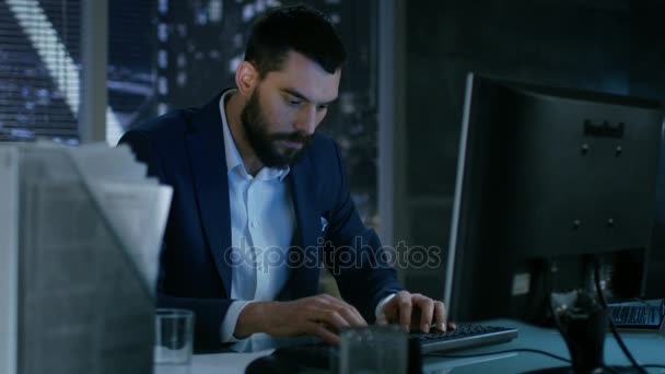 Tarde en la noche Empresario pierde la calma y golpea su monitor con el teclado . — Vídeos de Stock