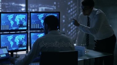 Gece geç saatlerde ofis bina güvenlik servis adamları var tartışma dikkatle gözlemleyerek monitörlerle konumu hassas bilgi gösterildiği onlara süre. 