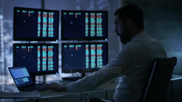 Tarde na noite Trader lê números em seus vários monitores com. Ele conseguiu vencer o Big on Stocks Trades. Em plano de fundo Vista da janela da cidade grande . — Vídeo de Stock