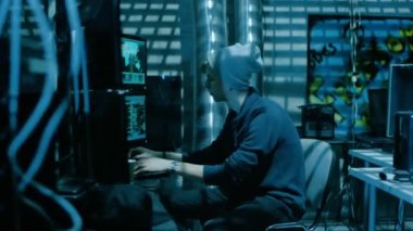 Siber Güvenlik sunucularından yeraltı saklandıkları saldıran genç hacker grubu. Her yerde karanlık atmosfer, birden çok ekran, kablolar yer vardır.