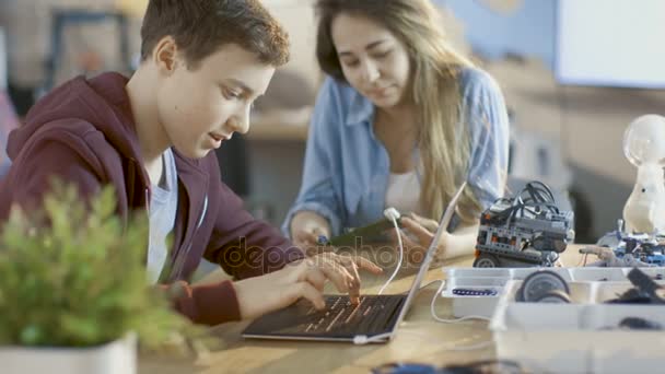 Meisje en jongen programma elektronisch apparaat met Laptop voor hun wetenschap / Robotic / Engineering klasse op School. — Stockvideo