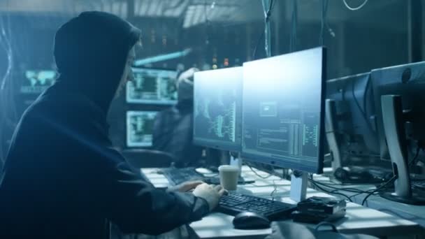 Team international gesuchter Teenager-Hacker bringt fortgeschrittenen Virenangriff auf Unternehmensserver mit. Ort ist dunkel und hat mehrere Displays. — Stockvideo